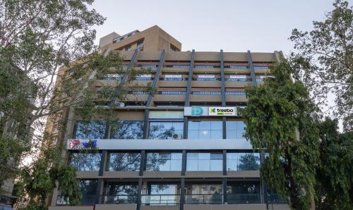 um edifício de escritórios com um sinal em frente em Treebo Trend Prince Plaza em Ahmedabad