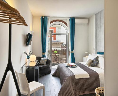 a bedroom with a bed and a chair and a window at Relais Quattro Fontane in Rome