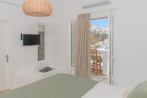 1 dormitorio con cama y vistas a un balcón en Korali en Astipalea