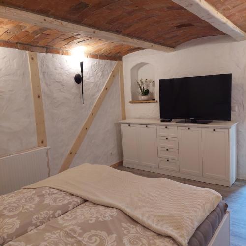 a bedroom with a bed and a flat screen tv at Spreewälder Sorbenstübchen in Radensdorf