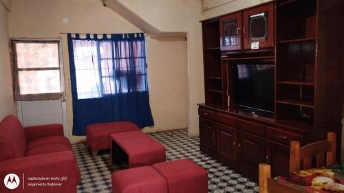 een woonkamer met een bank en een tv bij Flia brover (Lalo) in Puerto Iguazú