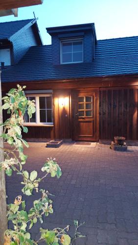 a house with a wooden door and a brick driveway at Spreewälder Sorbenstübchen in Radensdorf