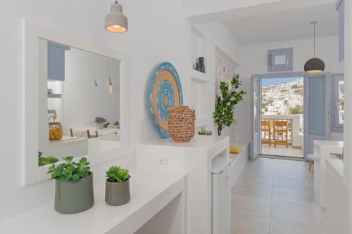 uma cozinha branca com vasos de plantas nos balcões em Korali em Astypalaia