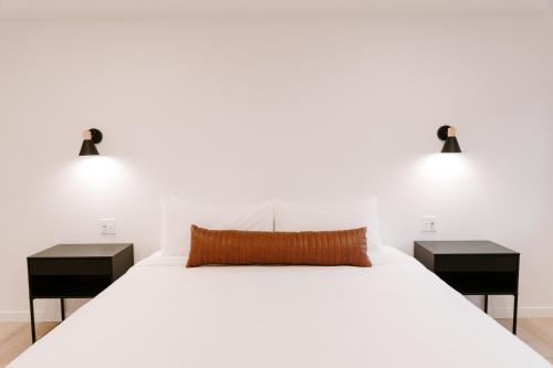 a bedroom with two nightstands and a large white bed at Nature Link Resorts in Nisswa