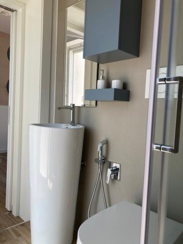 a bathroom with a white toilet and a sink at Ristella Home in Monopoli