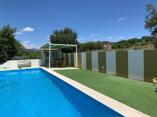 a swimming pool in a backyard with a fence at Casa Luz in Málaga