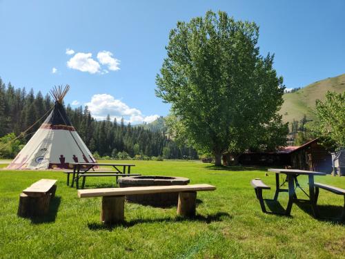 a field with picnic tables and a teepee at Southfork Lodge Cabin 2 in Lowman