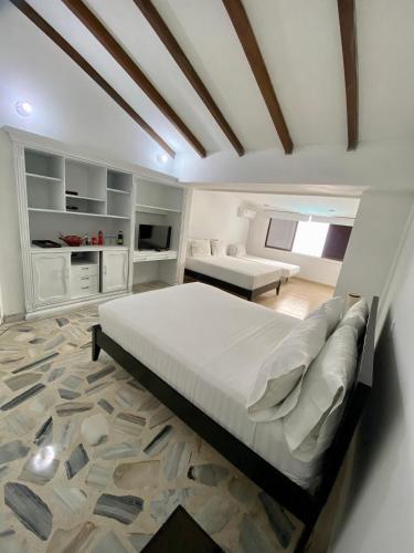 a bedroom with a large bed and a living room at San Laurent in Cali