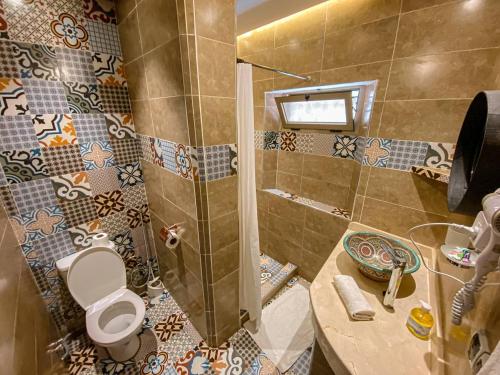 y baño con ducha, aseo y lavamanos. en Riad Zyna, en Meknès
