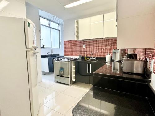 una cocina con electrodomésticos en blanco y negro y azulejos rojos en Ipanema Beach lovely apartment, en Río de Janeiro