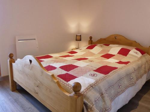 a bedroom with a bed with a red and white quilt at Appartement Méribel, 2 pièces, 4 personnes - FR-1-182-58 in Méribel