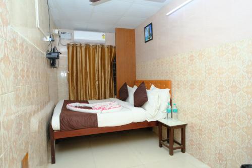 een slaapkamer met een bed en een bijzettafel bij Aum Karthikeya Residency in Chennai