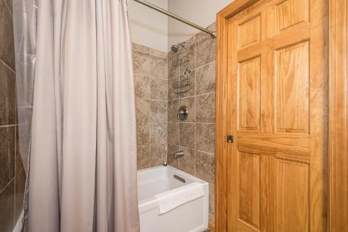 a bathroom with a shower curtain and a toilet at Bear Trap in Swanton