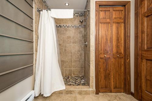 a bathroom with a shower with a white shower curtain at Bear Trap in Swanton