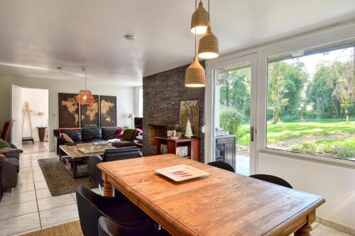 uma sala de estar com uma mesa de madeira e um sofá em Maison de charme à la campagne em Roupy