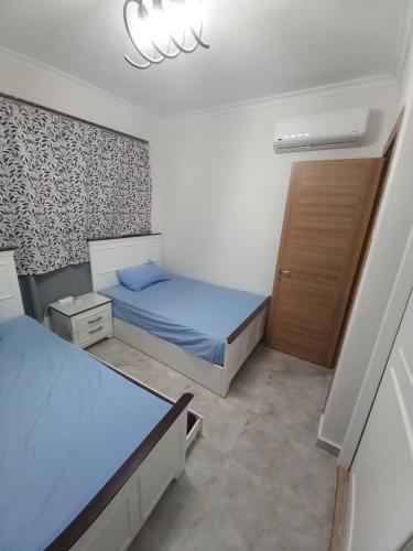 a small bedroom with a bed and a door at North Coast - New Alamein - for Families only Chalet - Sia Lagoon - Golf Porto Marina - للعائلات فقط الساحل الشمالى - العلمين الجديده - سيا لاجون - جولف بورتو مارينا in El Alamein