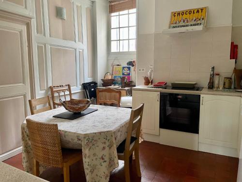 a kitchen with a table and chairs and a kitchen with a stove at L'Escapade Place Voltaire in Vermenton