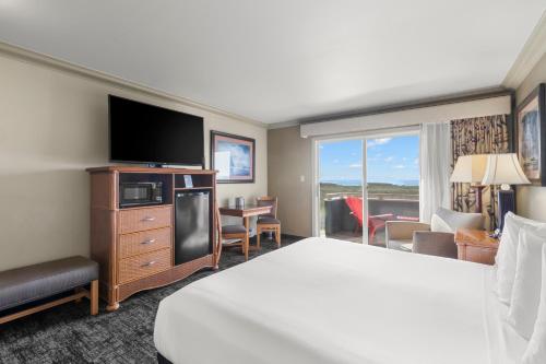 um quarto de hotel com uma cama e uma televisão de ecrã plano em Surf and Sand Lodge em Fort Bragg