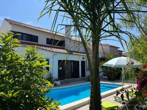 a villa with a swimming pool and a house at Casa Pausa Sesimbra Holiday Home in Sesimbra