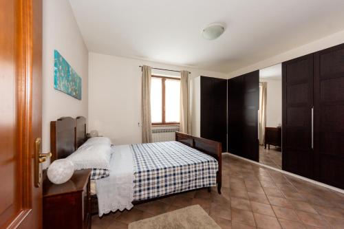 1 dormitorio con cama, ventana y puerta en Dory's apartment en Arquata Scrivia