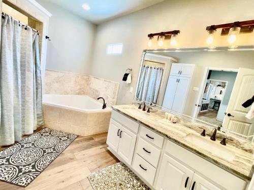 a bathroom with a tub and a sink and a mirror at SeaKing Relaxation where the waves meet the shore and time slows down in Port Aransas