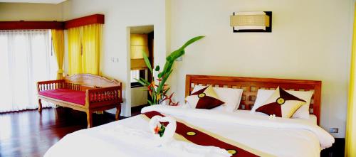 a bedroom with two beds and a chair at Phangka Paradise Resort in Taling Ngam Beach