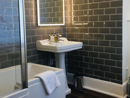 a bathroom with a sink and a bath tub at Westwood House in Dorchester