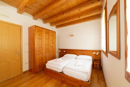 博爾索德爾格拉帕的住宿－Locanda 77，一间卧室配有白色床单