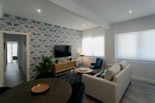 sala de estar con sofá y TV en Lujoso apartamento con piscina compartida 2 en Sevilla