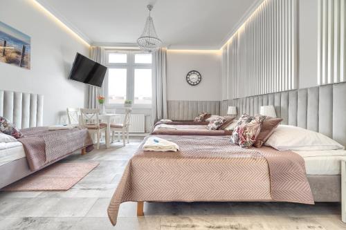 a bedroom with two beds and a dining room at Stawa Villa & Apart in Świnoujście