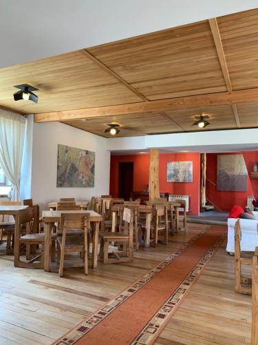 comedor con mesas y sillas de madera en Hosteria Posta de los Colonos en Villa La Angostura