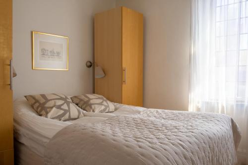 a bedroom with a bed and a window at Trerummare med havsutsikt i Visby innerstad in Visby