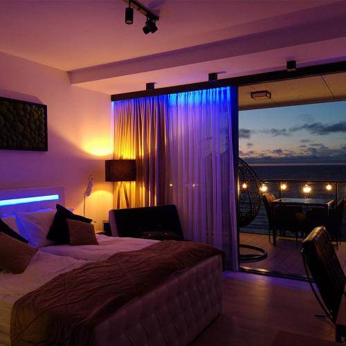 a bedroom with a bed and a view of the ocean at Sea View Moss VIP Apartment in Kołobrzeg