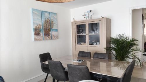 une salle à manger avec une table et des chaises en bois dans l'établissement Appartement T3 de 74m2 très lumineux vue panoramique mer et plages, à Concarneau