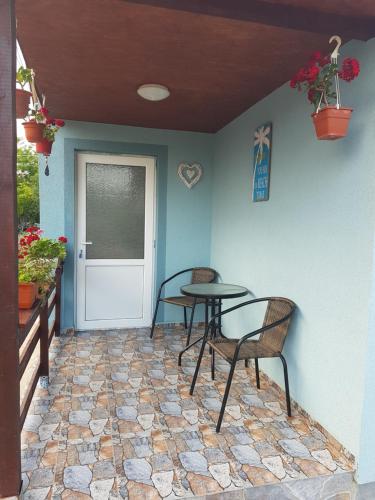 a patio with two chairs and a table and a door at La Dragalasu in Corbu