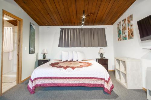 um quarto com uma cama grande e um tecto de madeira em The Pioneer Motel em Palmer