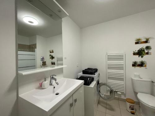 ein weißes Bad mit einem Waschbecken und einem WC in der Unterkunft Anvi Dream Paris Disney in Chessy