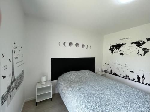 ein weißes Schlafzimmer mit einem Bett und einem schwarzen Kopfteil in der Unterkunft Anvi Dream Paris Disney in Chessy