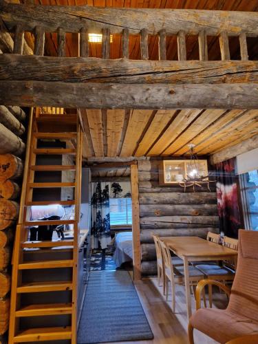 a room with a staircase and a table and chairs at Korpikelo in Ylläsjärvi
