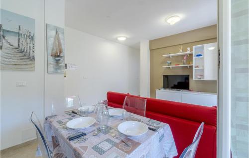 a dining room with a table and a red couch at Stunning Apartment In Recco With Wifi in Recco