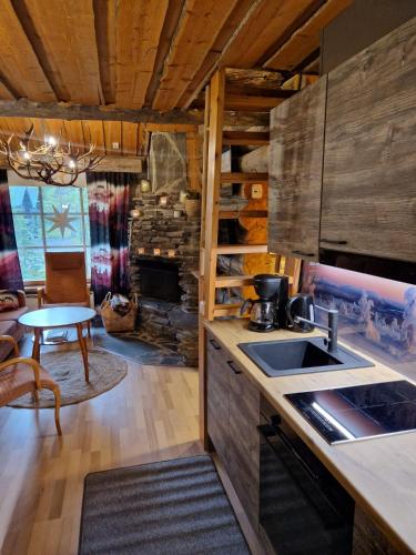 a kitchen and living room with a table and a fireplace at Korpikelo in Ylläsjärvi