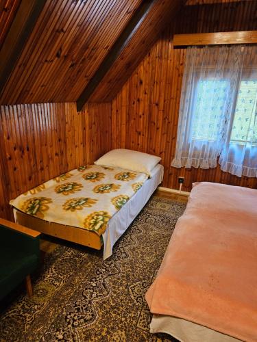 1 dormitorio con 2 camas y ventana en Chata Dajana en Stará Lesná