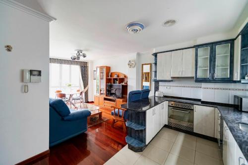 kuchnia z białymi szafkami i niebieską kanapą w obiekcie APARTAMENTO AVELINA w mieście Monforte de Lemos