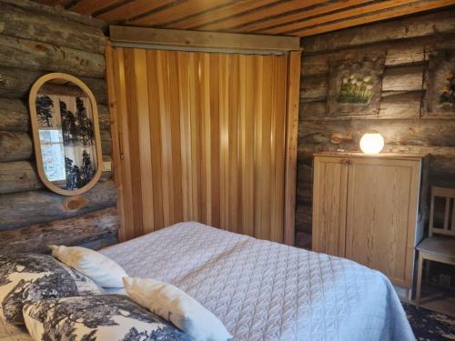 a bedroom with a bed in a log cabin at Korpikelo in Ylläsjärvi