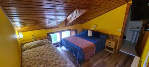 a bedroom with a bed and a wooden ceiling at Taberna de Tresviso in Tresviso