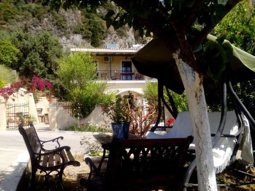 two chairs and a table in front of a house at Felicita in Paleokastritsa