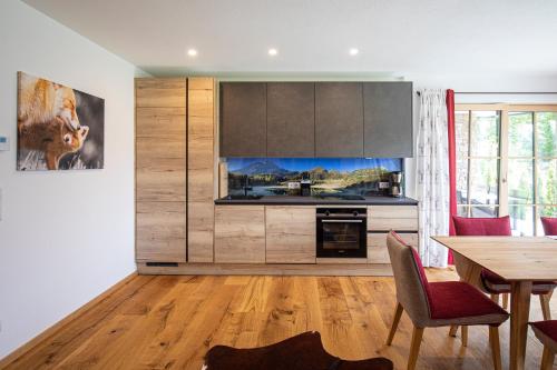 a kitchen with a table and a dining room at Dachstein Chalet in Russbach am Pass Gschütt