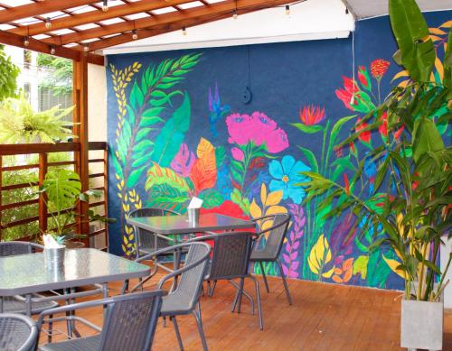 a restaurant with tables and chairs and a colorful wall at Hotel Boutique Casa del Hidalgo in Cali
