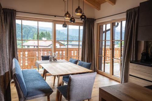 a dining room with a table and chairs and a large window at Dachstein Chalet in Russbach am Pass Gschütt