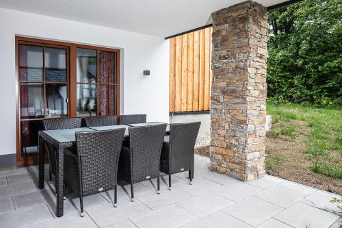 a patio with a table and chairs and a brick pillar at Dachstein Chalet in Russbach am Pass Gschütt
